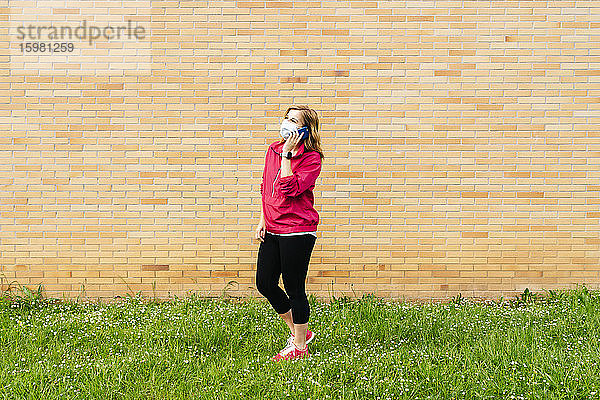 Frau mit chirurgischer Maske und Smartphone