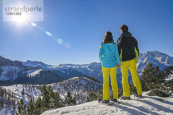 Rückansicht eines Paares beim Schneeschuhwandern am Jenner mit Blick auf die Landschaft