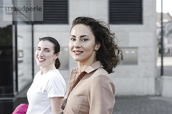Porträt von glücklichen multiethnischen Geschäftsfrauen vor einem Bürogebäude