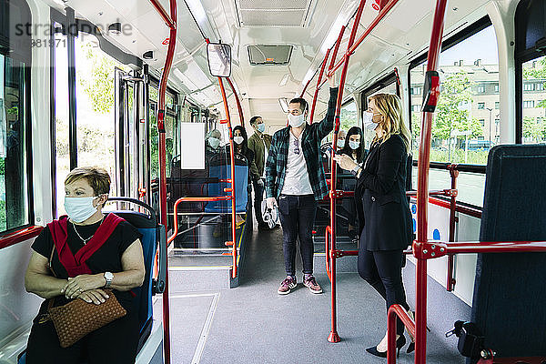Fahrgäste mit Schutzmasken in einem öffentlichen Bus  Spanien