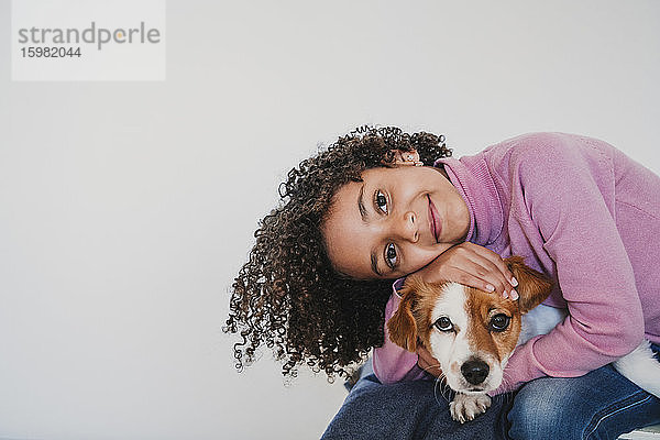 Porträt eines lächelnden kleinen Mädchens und ihres Hundes