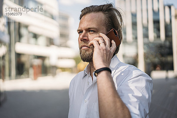 Porträt eines Geschäftsmannes beim Telefonieren in der Stadt