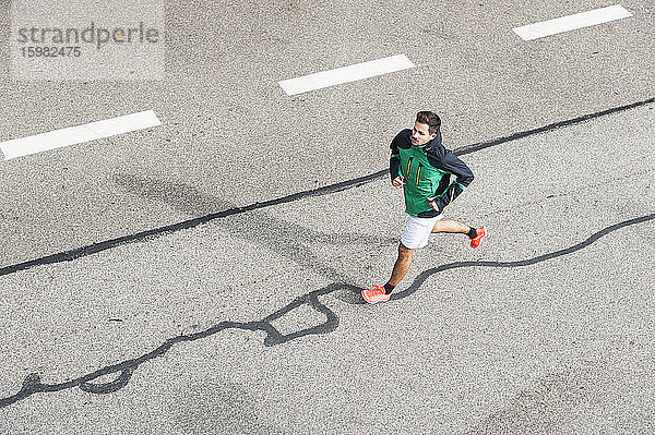 Vogelperspektive eines jungen Mannes  der auf einer Straße läuft