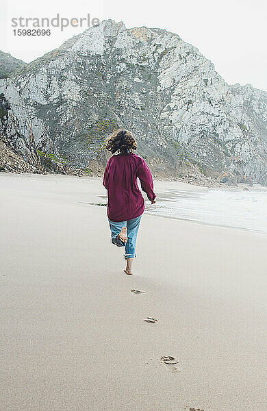 Young woman leaving footprints while running at Ursa Beach  Lisboa Region  Portugal