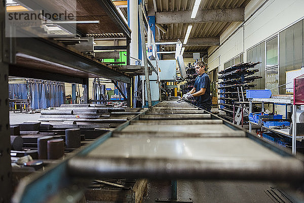 Ein Mann arbeitet an einer Maschine in einer metallverarbeitenden Fabrik