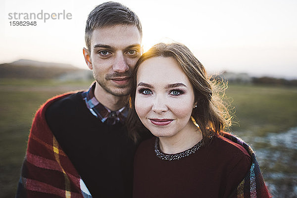 Ukraine  Krim  Junges Paar bei Sonnenuntergang mit Plaid bedeckt