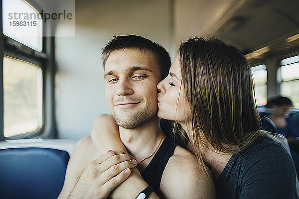 Junges Paar küsst sich im Zug