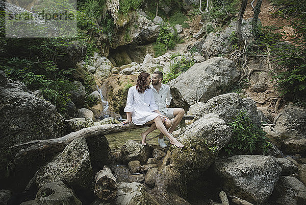 Ukraine  Krim  Junges Paar sitzt auf einem Ast über einem Fluss in einer Schlucht