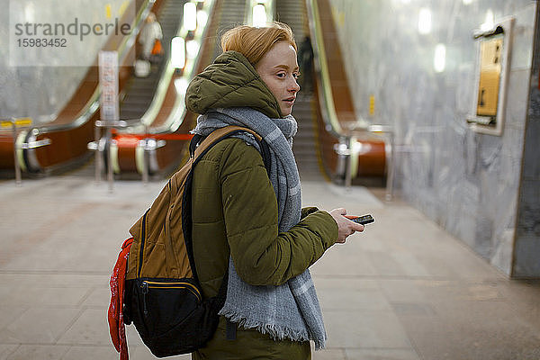 Russland  Nowosibirsk  Junge Frau steht an der Rolltreppe in der U-Bahn