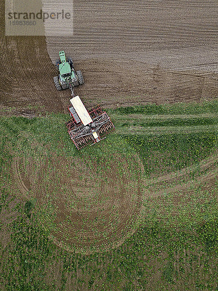 Russland  Luftaufnahme eines Traktors  der ein braunes Feld pflügt