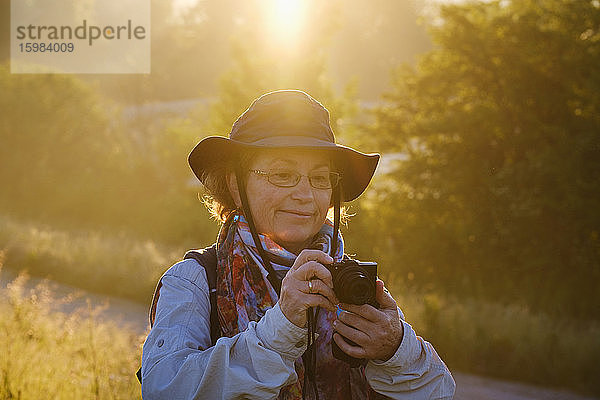 Ältere Wanderin schaut in die Kamera  während sie im Wald steht  Bayern  Deutschland
