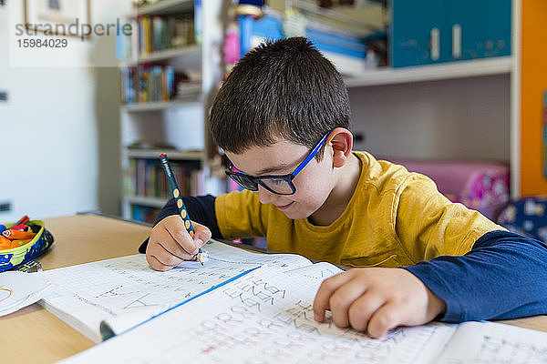 Grundschülerin lernt am Schreibtisch sitzend während des Hausunterrichts