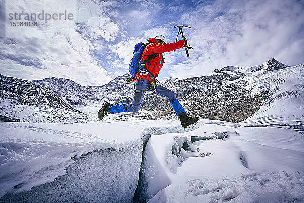 Bergsteiger beim Sprung über eine Gletscherspalte  Großvendigergletscher  Tirol  Österreich