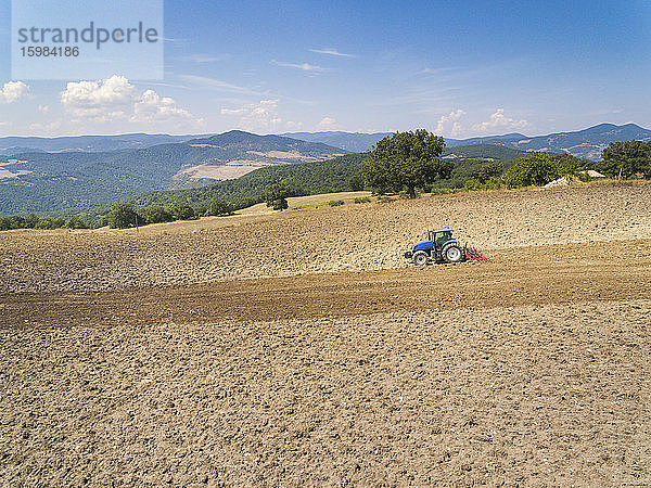 Traktor pflügt auf einem Bauernhof gegen den Himmel  Italien