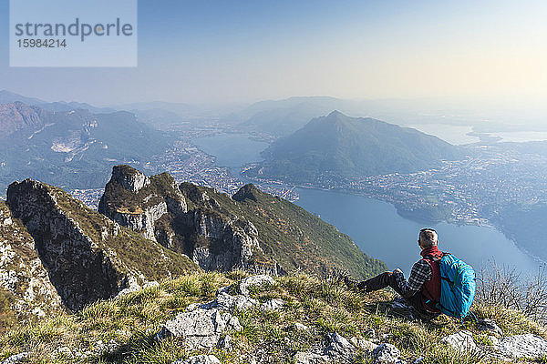 Rückansicht eines Wanderers  der auf einem Berggipfel sitzt  Orobie Alpen  Lecco  Italien