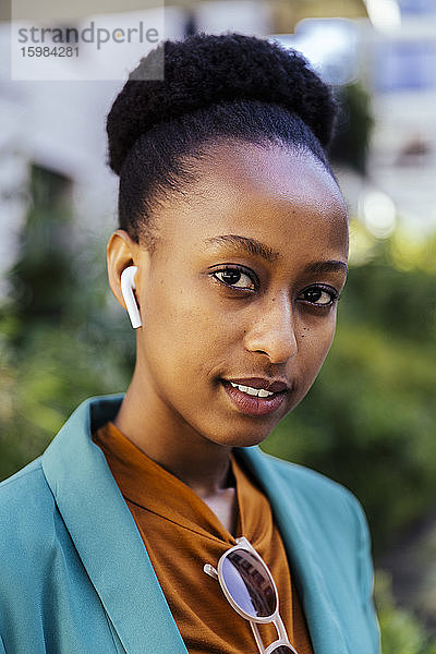 Porträt einer jungen Geschäftsfrau mit Ohrstöpseln
