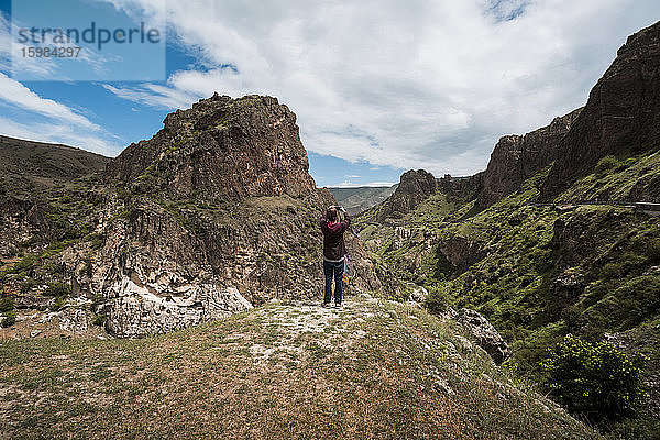 Georgien  Samtskhe-Javakheti  Männlicher Tourist fotografiert das Höhlenkloster Vardzia