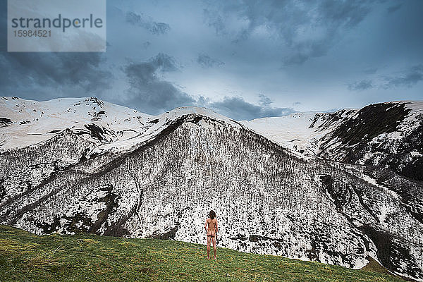 Georgien  Swanetien  Ushguli  Männlicher Nudist bewundert schneebedeckte Gipfel im Kaukasusgebirge
