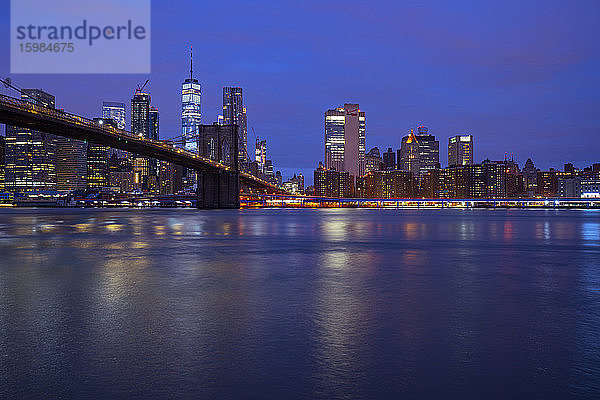 USA  New York  New York City  East River und Brooklyn Bridge in der lila Morgendämmerung mit der Skyline von Manhattan im Hintergrund