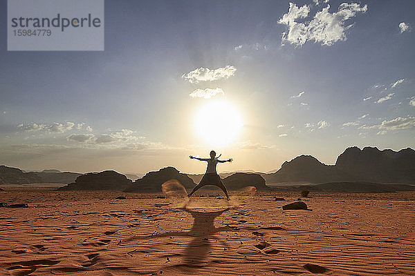 Frau  die in der Wüste von Wadi Rum  Jordanien  über den roten Sand springt