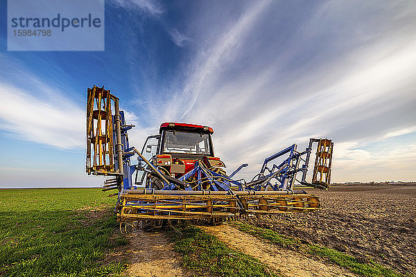 Traktor auf landwirtschaftlichem Feld gegen den Himmel