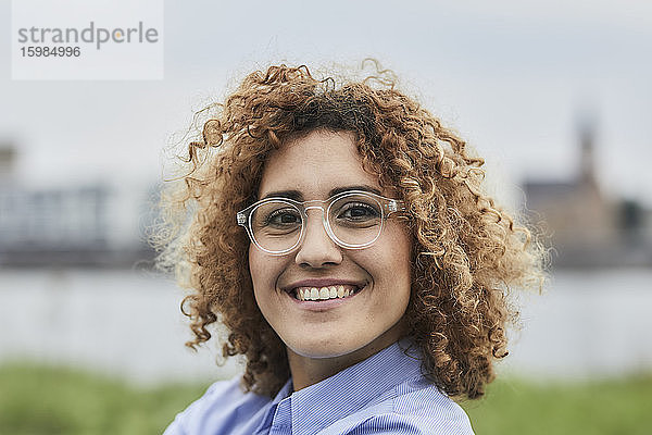Porträt einer lächelnden Geschäftsfrau mit Brille im Freien