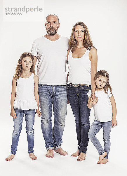 Porträt einer Familie mit zwei Töchtern vor weißem Hintergrund