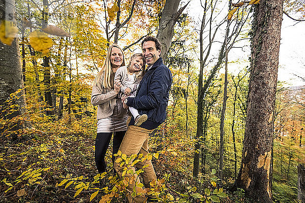 Porträt einer lächelnden Familie im Wald im Herbst