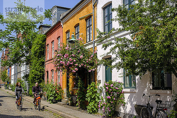 Dänemark  Kopenhagen  Mann und Frau auf Fahrrädern in der Straße des historischen Stadtteils Nyboder