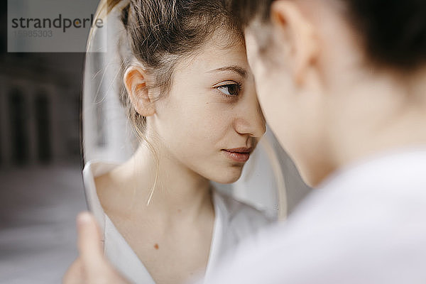 Nahaufnahme einer jungen Frau  die ihr Spiegelbild betrachtet
