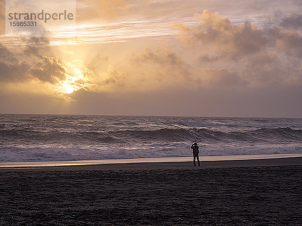 Island  Silhouette einer Person am Reynisfjara Strand