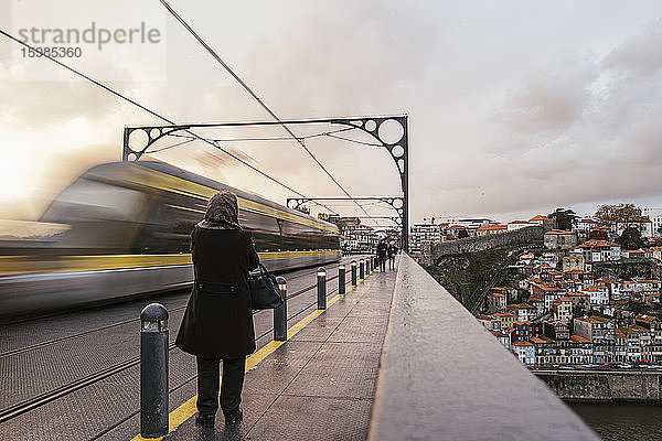 Portugal  Porto  Unscharfe Bewegung eines U-Bahn-Zugs  der in der Abenddämmerung eine Hochbahnstrecke passiert