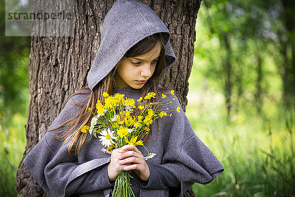 Mädchen hält einen Strauß gelber Wildblumen