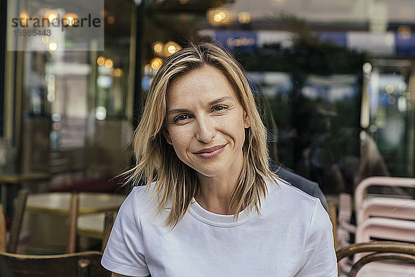 Porträt einer lächelnden Frau vor einem Kaffeehaus