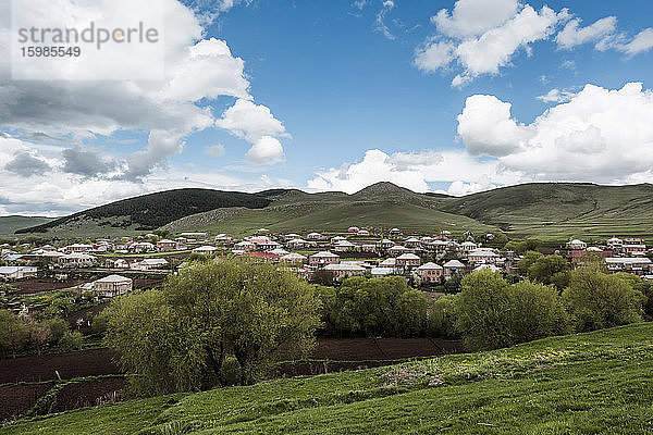 Georgien  Samtskhe-Javakheti  Wolken über einer Stadt auf dem Land mit Hügeln im Hintergrund