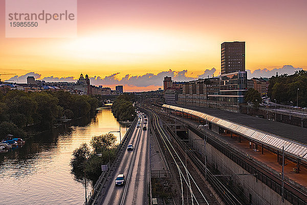 Schweden  Sodermanland  Stockholm  Autos passieren Gleise des Stockholmer Hauptbahnhofs bei Sonnenuntergang