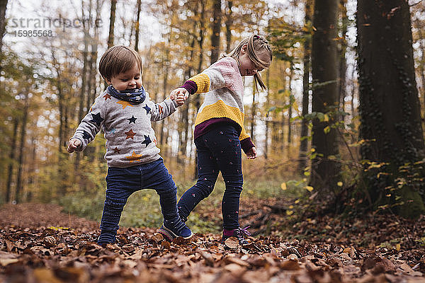 Deutschland  Baden-Wurttenberg  Lenningen  Zwei Kinder spielen im Herbstwald