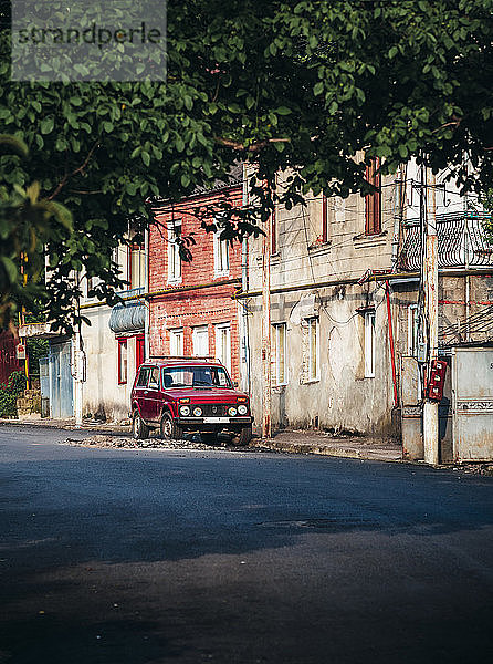 Georgien  Imereti  Kutaisi  Auto an alten Gebäuden geparkt