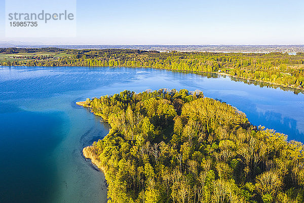 Deutschland  Bayern  Inning am Ammersee  Drohnenansicht des klaren Himmels über dem bewaldeten Ufer der Insel Worth