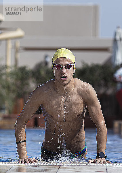 Entschlossener Schwimmer  der aus dem Pool einer Ferienanlage kommt  Dubai  Vereinigte Arabische Emirate