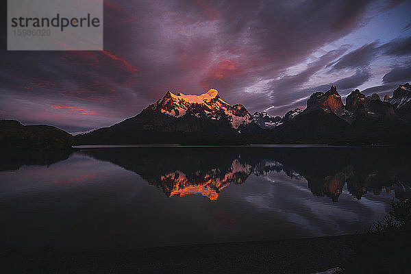 Chile  Berge spiegeln sich auf der Oberfläche eines glänzenden Sees im Torres Del Paine National Park bei dramatischer Abenddämmerung