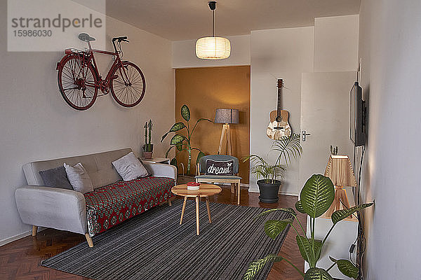 Wohnzimmer mit altem Fahrrad an der Wand