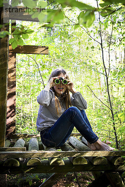 Porträt eines Mädchens mit Fernglas im Wald