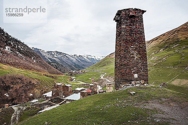 Georgien  Swanetien  Ushguli  Alter Backsteinturm mit Blick auf ein mittelalterliches Bergdorf