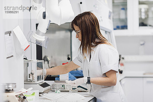 Selbstbewusste Technikerin mit Pillen in der Hand bei der Arbeit im Labor