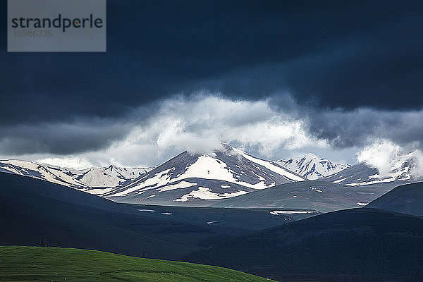 Georgien  Samtskhe-Javakheti  Poka  Dunkle Gewitterwolken über schneebedeckten Bergen