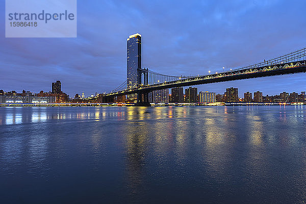 USA  New York  New York City  East River und Brooklyn Bridge in der blauen Morgendämmerung mit der Skyline von Manhattan im Hintergrund