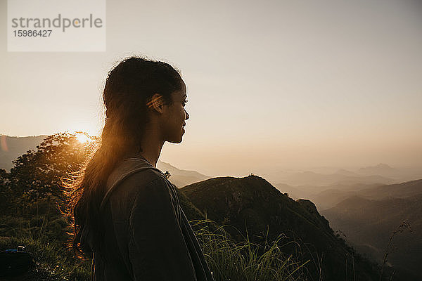 Wanderin beim Wandern auf einem Berg in Sri Lanka gegen den Himmel bei Sonnenuntergang  Sri Lanka