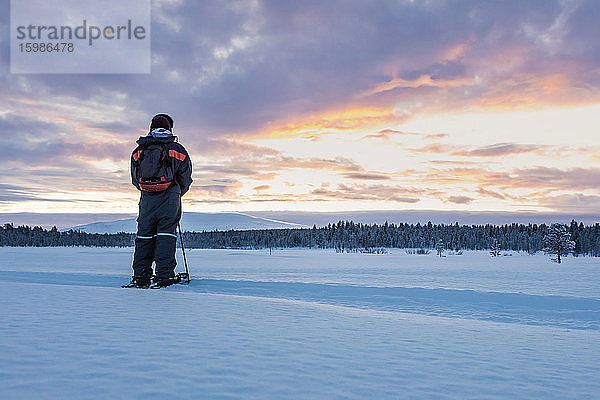 Rückansicht eines Schneeschuhwanderers in Winterlandschaft  Sotkajarvi  Enontekioe  Finnland