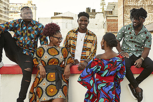 Freunde in bunter Kleidung auf einer Dachterrasse in der Stadt  Maputo  Mosambik